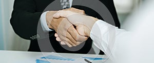 Panoramic banner. Partnership. two business man investor handshake deal with partner after finishing up business meeting on desk i