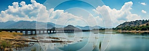 Panoramic beauty: dam, mountains, and clear blue sky create a stunning vista