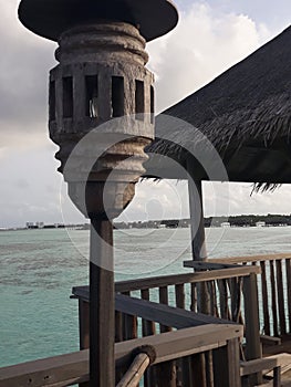 panoramic behind charming wooden railings along with a small hut above watervilla resort in gili lankanfushi maldives