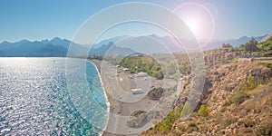 Panoramic bird view over Antalya modern part of the city, Mediterranean seacoast and long pebble beach with tourists and with lens