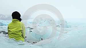 Panoramic cinematic view of tourist by Fjallsjokull glacier in Iceland from inside glacier cave. Explore sightseeing Iceland