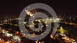 Panoramic drone view of the coastal city at dusk under pyrotechnic fires