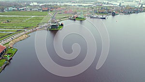 Panoramic drone view of Zaans Schans turning windmills by the water channel near Amsterdam, Netherlands