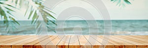 Panoramic empty clean wood counter table top blur shinny white bokeh light on summer beach background for product morning scene photo