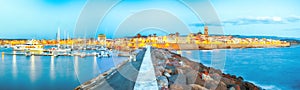 Panoramic evening cityscape of  Alghero port and historical part of cit