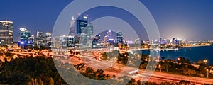 Panoramic evening view of illuminated skyscrapers and traffic in downtown Perth, Western Australia.