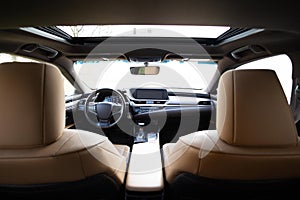 Panoramic glass sun roof in the car. Sliding panoramic sunroof and luxurious leather seats. Prestige modern Inside car