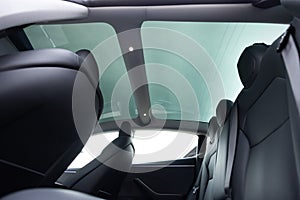 Panoramic glass sun roof in the modern electric car. Clean sunroof and view at the sky from the inside or car interior