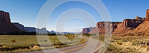 Panoramic. The Highway Leading In To Canyonlands, Utah. Blue Sky, Red Rocks, Green Grass, Remote Location