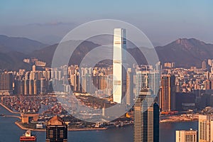 Panoramic of Hong Kong city view, modern cityscape bay with cargo barges during sunset in the evening amazing warm toned