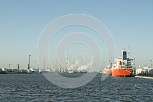 Panoramic image of petrochemicals in the port of Antwerp with moored ships and steam coming out of the chimneys