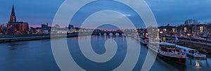 Panoramic image of the skyline of Maastricht during the blue hour with views on the Sint Servaas bridge, the boat company for day