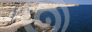 Panoramic landscape of Black sea rocks at coastline with clear blue waters in Crimea