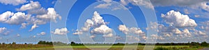 Panoramic landscape with blue sky and puffy clouds