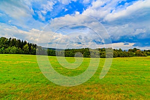 Panoramic landscape of colorful yellow-green hills, blue sky and clouds