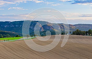 Panoramic landscape of colorful yellow-green hills with ground road, blue sky and clouds