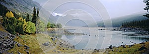 Panoramic landscape of misty lake with autumn foliage