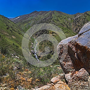 Panoramic landscape with mountain river with cascades of waterfalls in field in Kaskasu gorge in summer in Kazakhstan