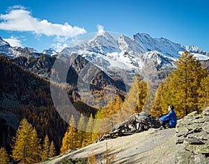 Panoramic landscape of a trekker relaxing on the mountains. Gran Paradiso National Park. Italy