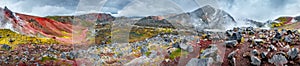 Panoramic landscape view of colorful rainbow volcanic Landmannalaugar mountains and two hikers at hiking trail path with dramatic