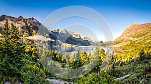 Panoramic landscape view of Glacier NP mountain range and lake