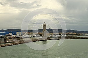 Panoramic landscape view port of Livorno, Italy. Moored luxury yachts and ships. Breakwater and ancient lighthouse in the harbor.