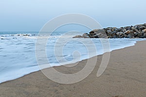 Panoramic landscape view of silky and foamy sea waves of Arabian Sea, swashing on rocky and sandy Gokarna Main Beach or Gokarna