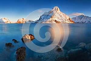 Panoramic landscape, winter mountains and fjord reflection in water. Norway, the Lofoten Islands.