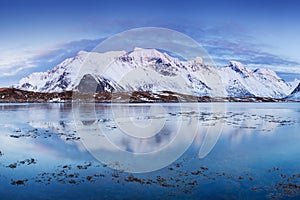 Panoramic landscape, winter mountains and fjord reflection in water. Norway, the Lofoten Islands.