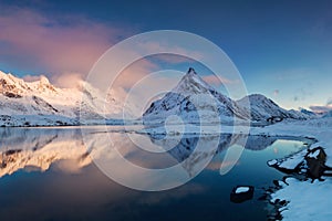 Panoramic landscape, winter mountains and fjord reflection in water. Norway, the Lofoten Islands.