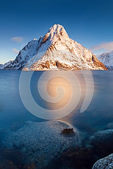 Panoramic landscape, winter mountains and fjord reflection in water. Norway, the Lofoten Islands.