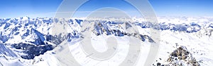 Panoramic landscape Winter view from the top of Kitzsteinhorn mountain on snow covered slopes, blue sky. Kaprun ski