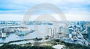 Panoramic modern city skyline bird eye aerial view of Odaiba bay and bridge under dramatic sunrise and morning blue cloudy sky in