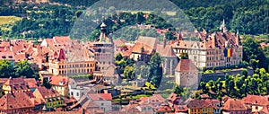 Panoramic morning cityscape of Sighisoara with Clock Tower and City Hall. Sunne summer view of medieval town of Transylvania, Roma