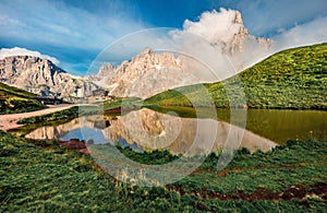 Panoramic morning view of Baita Segantini mountain refuge with Cimon della Pala peak. Stunning summer scene of Dolomiti Alps,