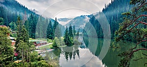 Panoramic morning view of Lacu Rosu lake. Misty summer scene of Harghita County, Romania, Europe. Beauty of nature concept backgro