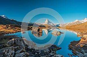 Panoramic morning view of Lake Stellisee with the Matterhorn Cervino Peak in the background. Impressive autumn scene of