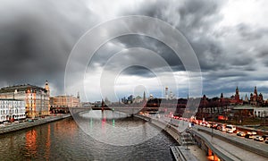 Panoramic Moscow view with riverbank and water reflections under dramatic cloudy sky