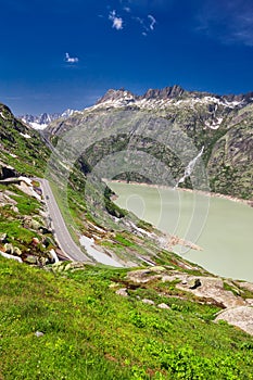 Panoramic mountain road leading to Grimselpass with Grimselsee in Swiss Alps