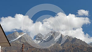 Panoramic movement of fuzzy floating Clouds flowing over Mountain summit in Blue sky backdrop. Nature background. Copy space room