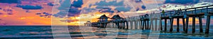 Panoramic of the Naples pier at sunset with a glowing sun in Florida, USA