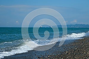 Panoramic nature background with pebble beach, mountains and sea port.