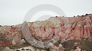 Panoramic nature landscape in Cappadocia with sandy red beige mountains, Turkey.