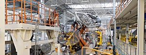 Panoramic photo of automobile production line. Welding car body. Modern car assembly plant. Auto industry