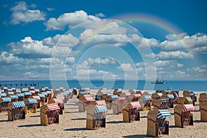 A panoramic photo of colorful beach chairs on the beach in beautiful weather
