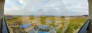 Panoramic photo from the height of residential buildings and power plant under construction in summer. Urban expansion concept