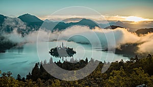 Panoramic photo of lake Bled island with church on a cold hazy foggy early autumn morning from Ojstrica vantage point. Visible