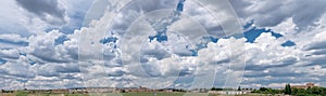Panoramic picture of small town and stunning skyscape with cumulus clouds photo