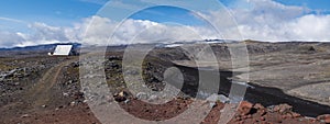 Panoramic red and black volcanic Iceland landscape with mountain hut shelter Baldvinsskali at Fimmvorduhals pass on hiking trail