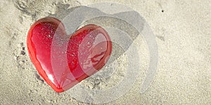 A panoramic with red and shiny heart with some sand